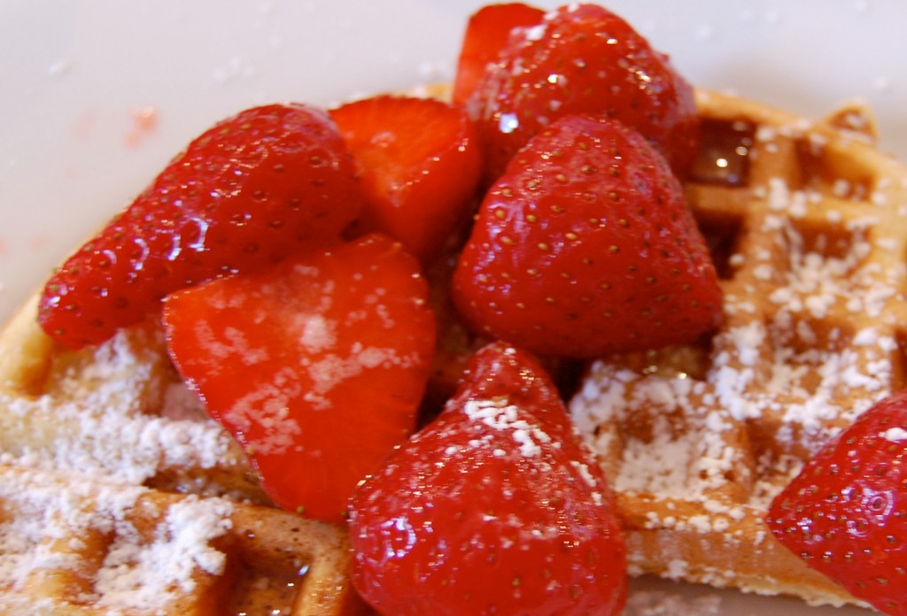 Close-up of Belgian waffles with strawberries and powdered sugar